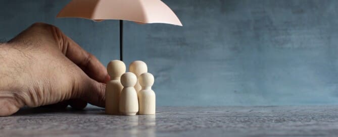 Umbrella and wooden dolls with copy space. Family protection and