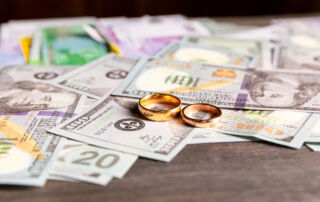 Image of two wedding rings on dollar bills.