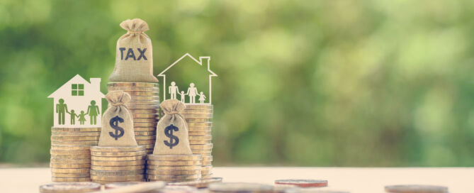 Image of a model house with coins in front of it