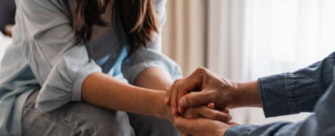 Young man comforting and supporting a sad woman who is in serious trouble at home, Consolation and encouragement concept