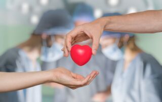 Heart transplant and organ donation concept. Hand is giving red