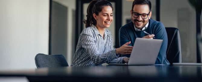 Portrait of two business colleagues, looking at something online